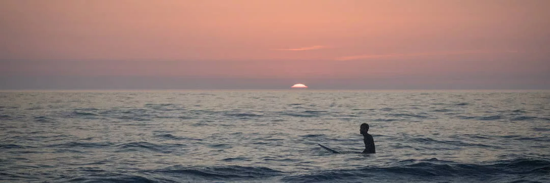 Surfer from Australia enjoying some waves in the UK freeing his mind of tax obligations, tax rules, and tax bills