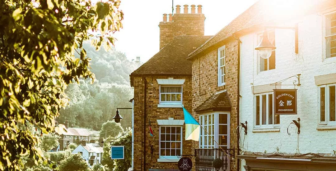 tops section of English village shops with sun setting behind them