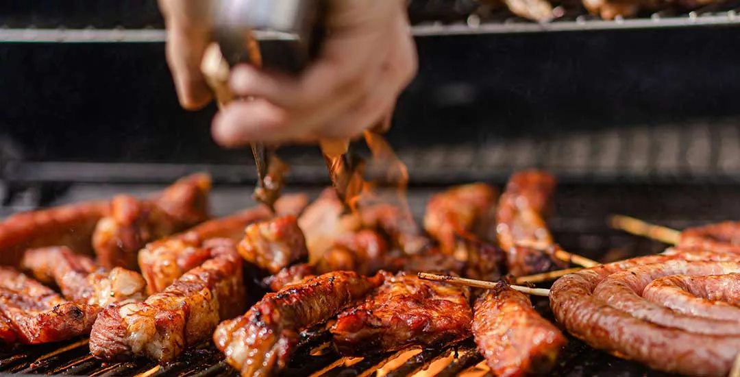 ribs and sausages being cooked on a bbq