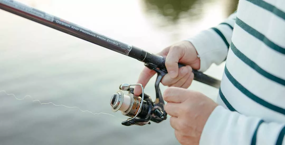 close up of person holding a fishing rod