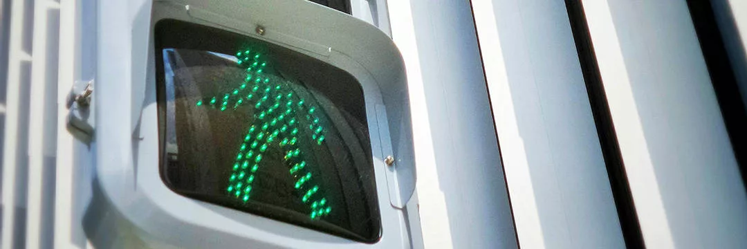 controlled pedestrian walk way sign showing green walking signal