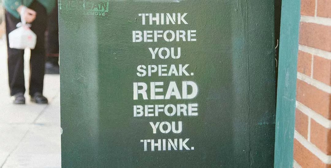 side of a green bin with the words think before you speak. READ before you think on the side in white paint