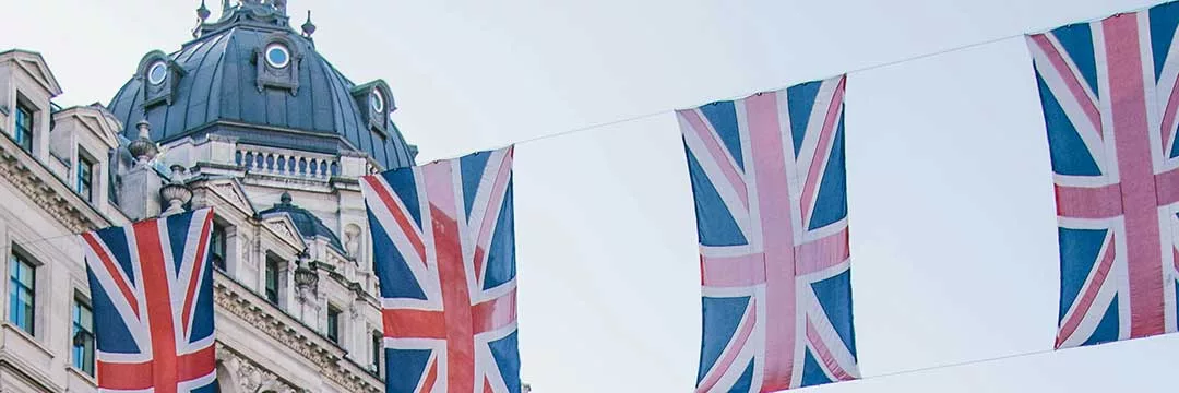 scene of London showing union jack flags to introduce English capital gains tax rates.