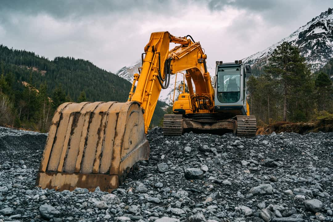 Digger on rocks while owner considers getting tax relief of equipment purchases in 2023