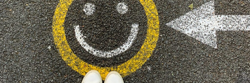 image of a person standing and looking down at a smiley face with an arrow pointing to it to illustrate the relief from double taxation and the cooperation between the two countries.