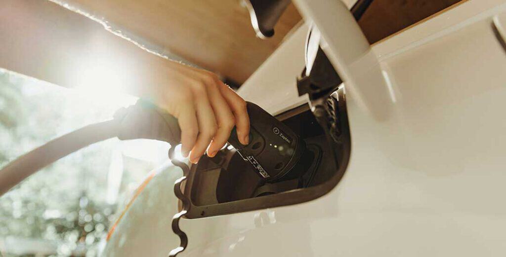 person plugging in their electric car