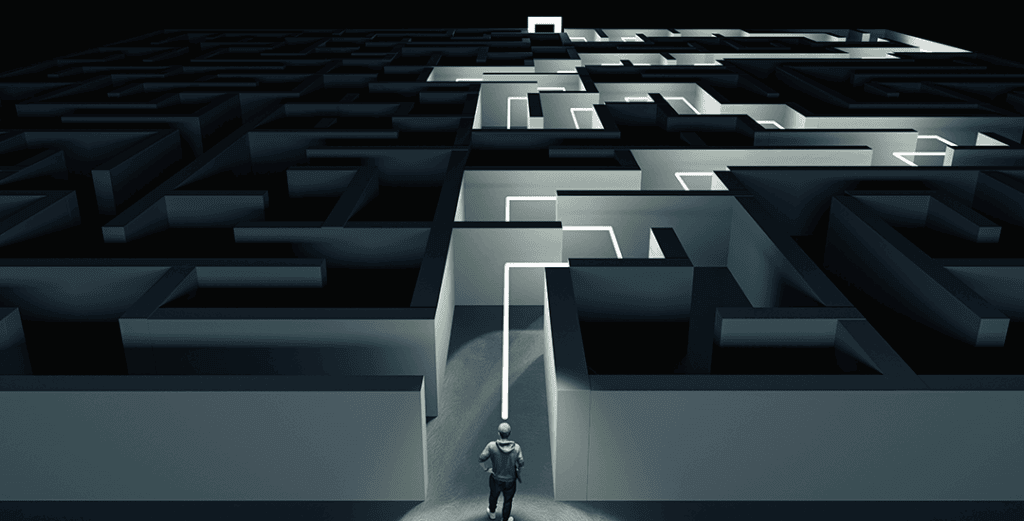 image of man standing in front of dark maze with the pathway through lit